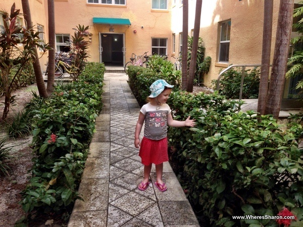 toddler standing playing with planets in south beach apartment complex