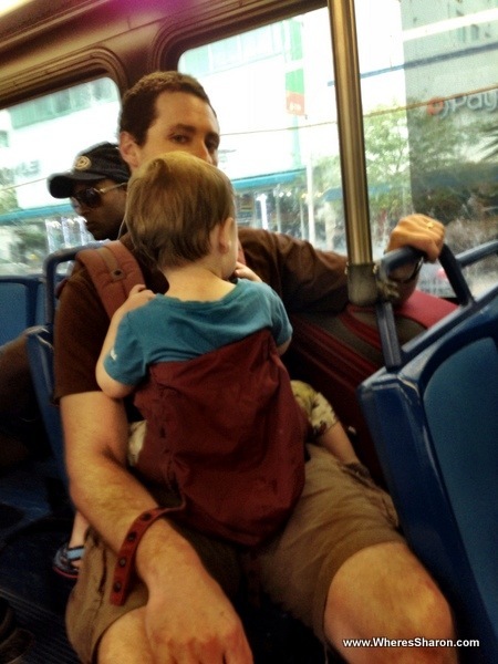 Baby and man with a suitcase on a miami bus