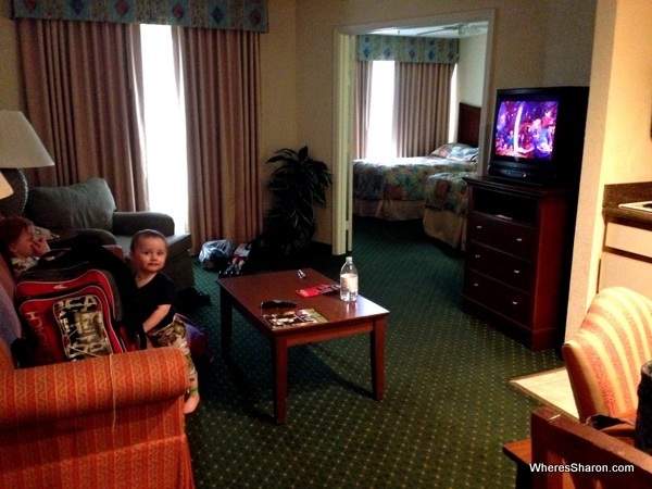 Lounge room and couch with bedroom in background at palms hotel and villas kissimmee