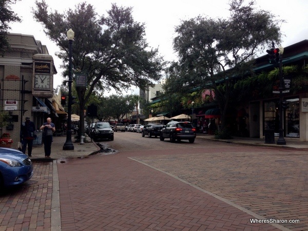 The street with cars trees and pretty buildings in Winter Park orlando