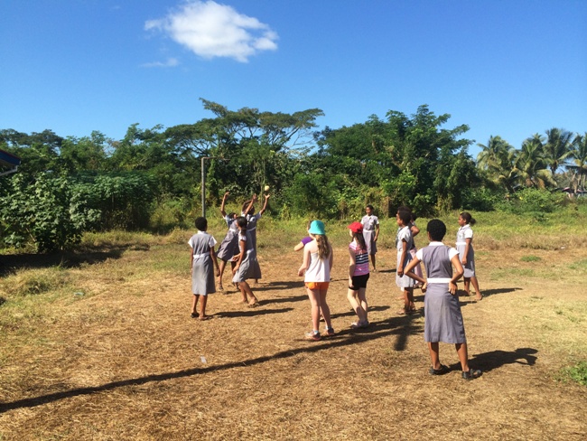 Visitors joining students in a netball game at a Fijian school